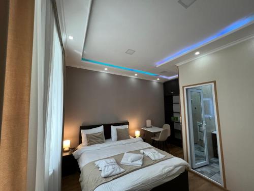 a bedroom with a bed with a blue light on the ceiling at Serenity Likani Villa Hotel in Borjomi