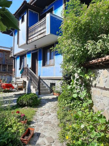 una casa azul y blanca con un camino de piedra delante de ella en Guest House Edelweiss, en Koprivshtitsa
