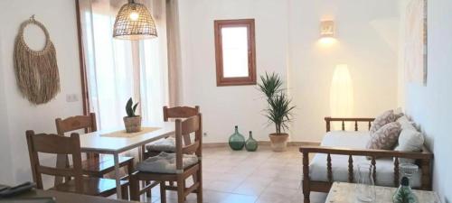 a living room with a table and chairs at Apartamentos Can Salas in Cala Figuera