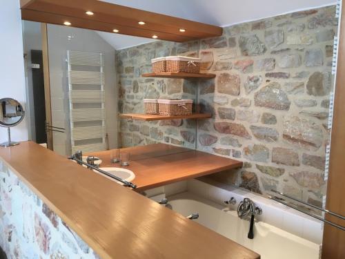 a bathroom with a sink and a stone wall at Baronheid in Francorchamps