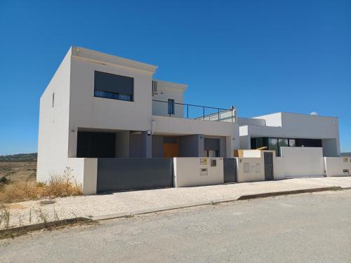 a white house on the side of a road at Villa Ria Alvor- Swimming pool & Jacuzzi in Mexilhoeira Grande