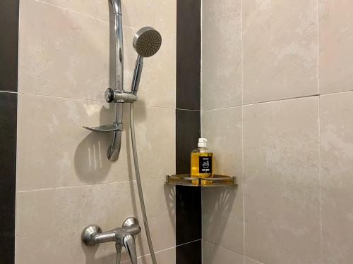 une douche avec une bouteille de savon sur une étagère dans l'établissement PLAY at Nova Retreat Kea Farm, à Cameron Highlands