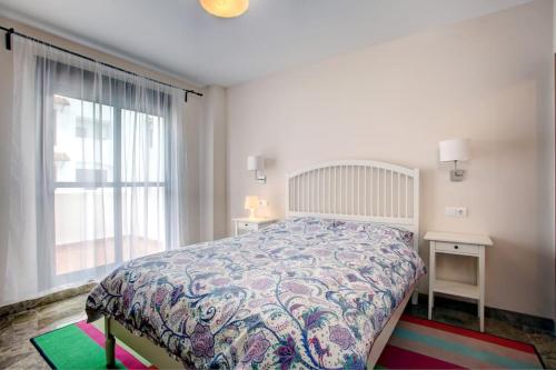 um quarto com uma cama e uma grande janela em Luxury apartment in Golf Hills, Estepona. em Estepona
