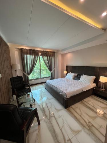 una grande camera da letto con un grande letto e una sedia di Ortus - Murree Hills a Murree