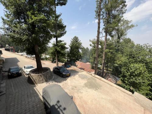 a camper and cars parked in a parking lot at Ortus - Murree Hills in Murree