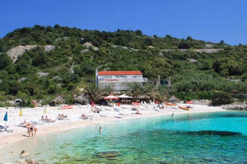a beach with a group of people in the water at Rooms by the sea Hvar - 8785 in Hvar