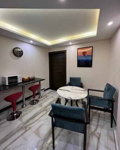 a living room with a table and chairs at Ortus - Murree Hills in Murree