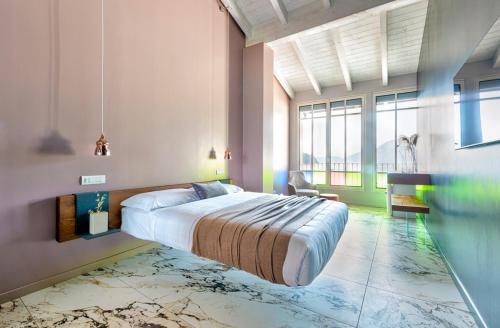 a bedroom with a large bed and a large window at Vulcano Palace in Castro