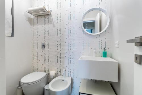 a white bathroom with a toilet and a mirror at La Dimora della Luna in Pozzallo