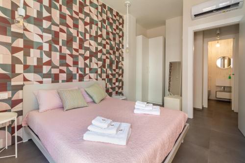 a bedroom with a pink bed with towels on it at La Dimora della Luna in Pozzallo