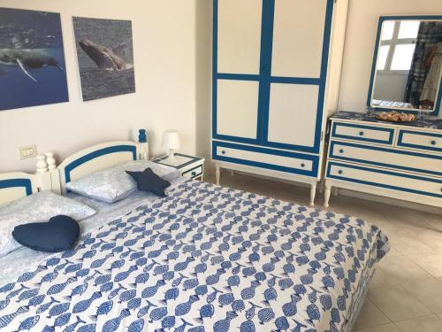 a bedroom with a blue and white bed and a dresser at Sea view house, Praia de Chaves, Boa Vista, Cape Verde, FREE WI-FI in Cabeçadas
