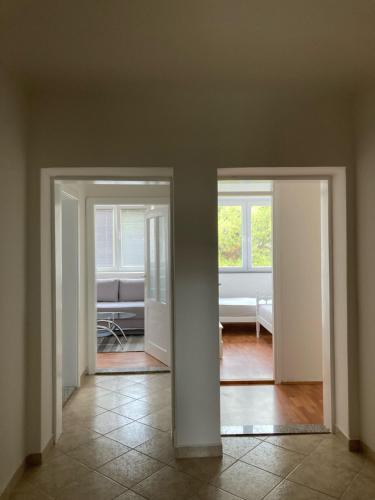an empty room with two doors and a living room at Apartman Jelena in Mostar