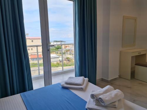 a room with a bed and a window with towels at Apartments Mario in Ksamil