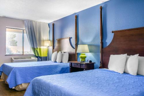 2 Betten in einem Hotelzimmer mit blauen Wänden in der Unterkunft Rodeway Inn near Ft Huachuca in Sierra Vista