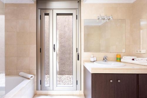 a bathroom with a tub and a sink and a mirror at Chalet con vistas al mar en Santa Cruz de Tenerife in Santa Cruz de Tenerife