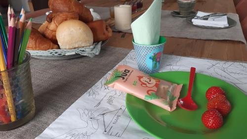 a green plate with strawberries on a table at Zee-van-Tijd in Oudenburg