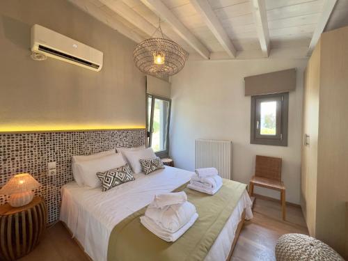 een slaapkamer met 2 bedden en handdoeken bij Bouboulina's house with amazing sea view in Skiathos-stad