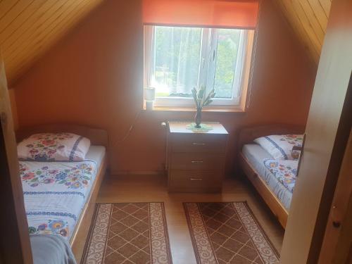 een kleine kamer met 2 bedden en een raam bij Domek u Ani in Orelec