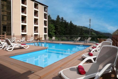 a hotel swimming pool with chaise lounge chairs at Best Western Plus Paradise Hotel Dilijan in Dilijan