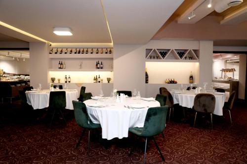 a dining room with white tables and green chairs at Best Western Plus Paradise Hotel Dilijan in Dilijan