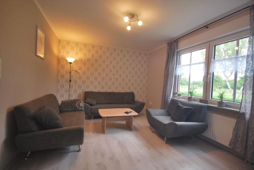 a living room with two chairs and a couch and a table at Ferienwohnung Up Hobarg 35523 in Uplengen