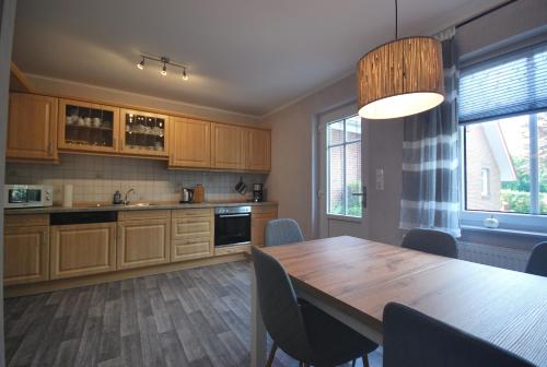 a kitchen with a wooden table and a dining room at Ferienwohnung Up Hobarg 35523 in Uplengen
