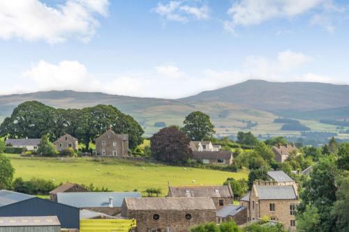 a small village with mountains in the background at Ingleborough View in Carnforth