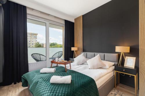 a hotel room with a bed and a balcony at Solaris Park Apartments Tauron Arena by Renters Prestige in Krakow