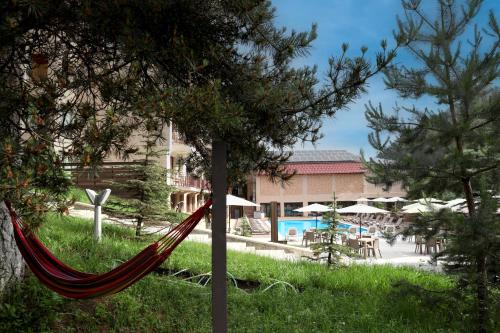 a hammock in front of a resort with a pool at Best Western Plus Paradise Hotel Dilijan in Dilijan