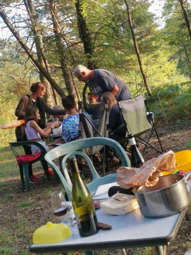 Un groupe de personnes assis à une table de pique-nique dans l'établissement air naturel de camping moulin de malesse, à Saint-Privat