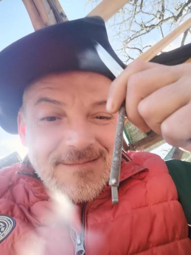 un homme portant un chapeau et tenant un couteau dans l'établissement air naturel de camping moulin de malesse, à Saint-Privat