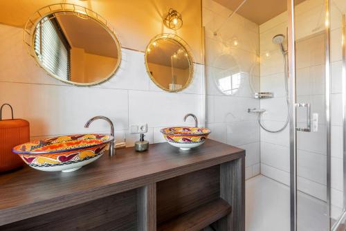 a bathroom with two sinks and two mirrors at The Mex - El Sombrero in Arnstadt