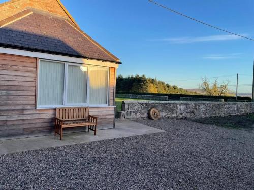 a wooden bench sitting outside of a house at Glen Cottage 8 Fenton Hill Farm in Wooler