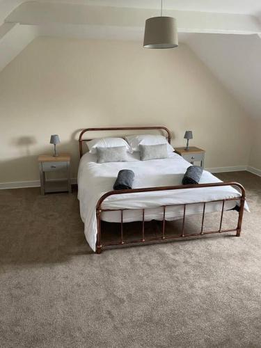 a bedroom with a bed with white sheets and pillows at Tweed Cottage 4 Fenton Hill in Wooler