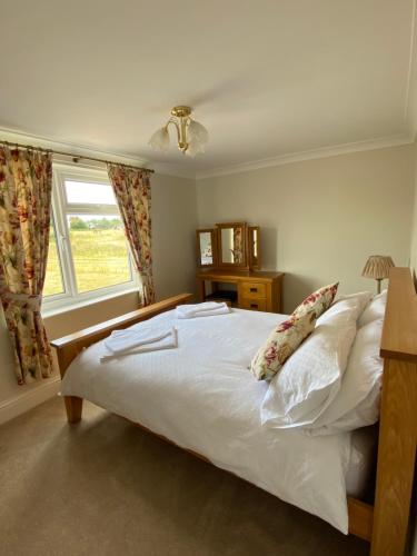 a bedroom with a white bed with a window at Beautiful newly renovated 5 bedroom farmhouse in Belton
