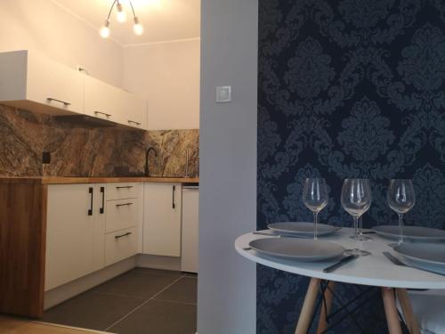 a kitchen with a table with wine glasses on it at Apartamenty EverySky Nad Łomnicą 15-15A in Karpacz