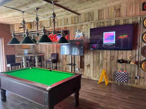 a room with a pool table and a tv at Hatters Hotel in Skegness