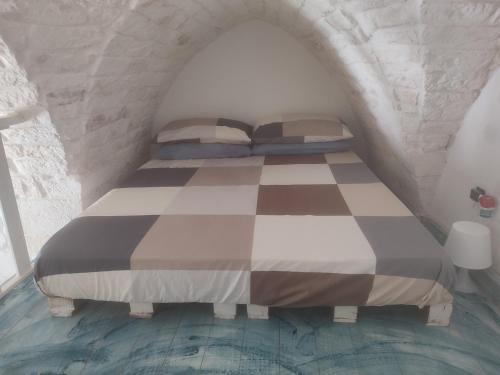 een slaapkamer met een bed en een geruite vloer bij Le Terrazze Ferrigni in Ostuni