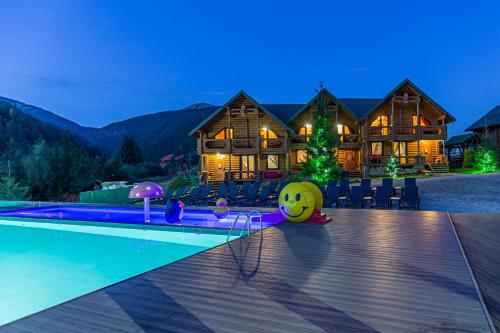 ein Blockhaus mit einem Pool und einem Haus in der Unterkunft Красна Поляна Family Club Resorts in Bukowel