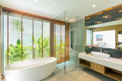 a bathroom with two sinks and a tub and a large window at Ananas villa Shambala grand Cherng Talay in Bang Tao Beach