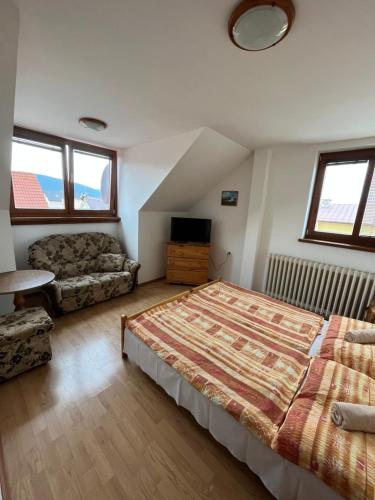 1 dormitorio con 1 cama y 1 sofá en Penzion Siesta Grand, en Hrabušice