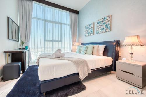 a bedroom with a large bed and a large window at Classy 1BR at Bayz by Danube Business Bay by Deluxe Holiday Homes in Dubai