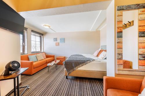 een slaapkamer met een bed en een bank in een kamer bij The Mex - El Sombrero in Arnstadt