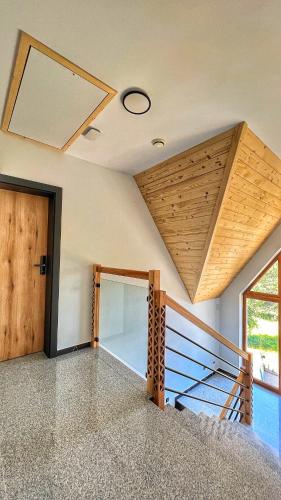 a room with a staircase with a wooden ceiling at Apartamenty Widok Tatr in Zakopane