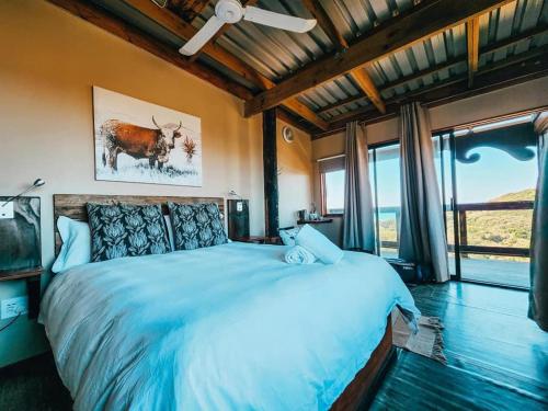 1 dormitorio con cama grande y ventana grande en CORAM DEO SaltyWaves double en-suite rooms with sea views en Coffee Bay
