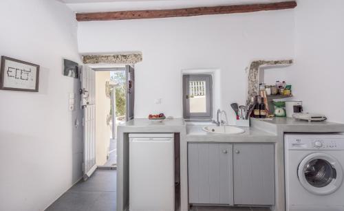 a kitchen with a sink and a washing machine at Olive Cottage in Zefiría