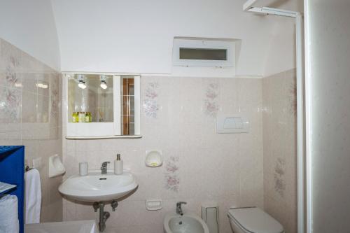 a white bathroom with a sink and a toilet at Casa Betty in Positano
