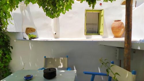 a table with vases on shelves in a room at Grandpa's Traditional Guesthouse in Amorgos