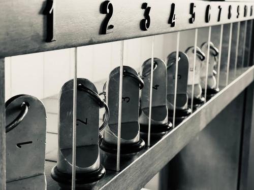 a row of cups on a shelf with numbers on them at Hotel Al Bosco in Sona