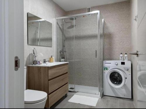 uma casa de banho com um chuveiro e uma máquina de lavar roupa em Apartamento Ronda IV - Los Boliches em Fuengirola